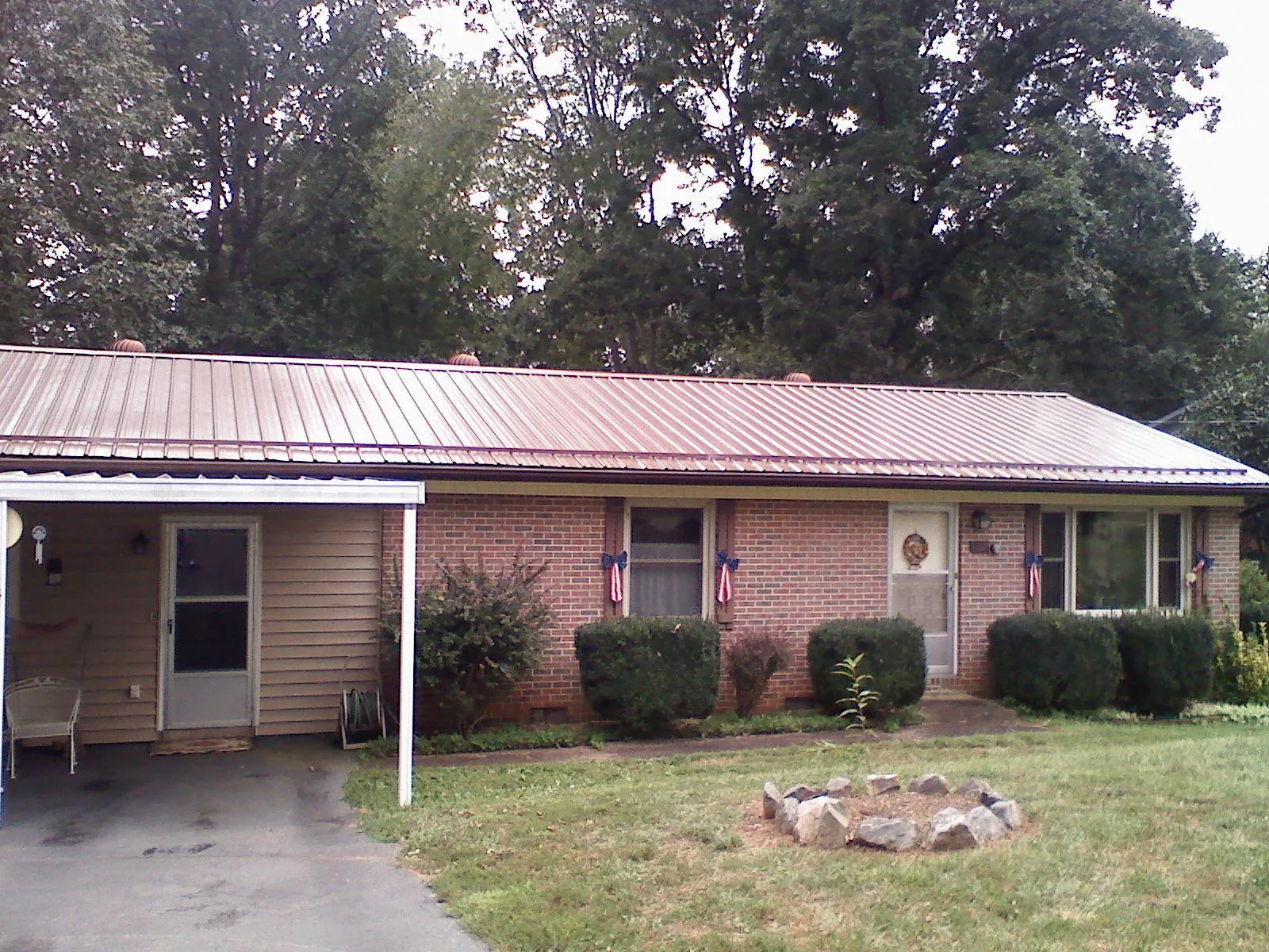 Bronze metal roof and carport on a brick ranch home — Roof Repair work by our crew in Columbia City